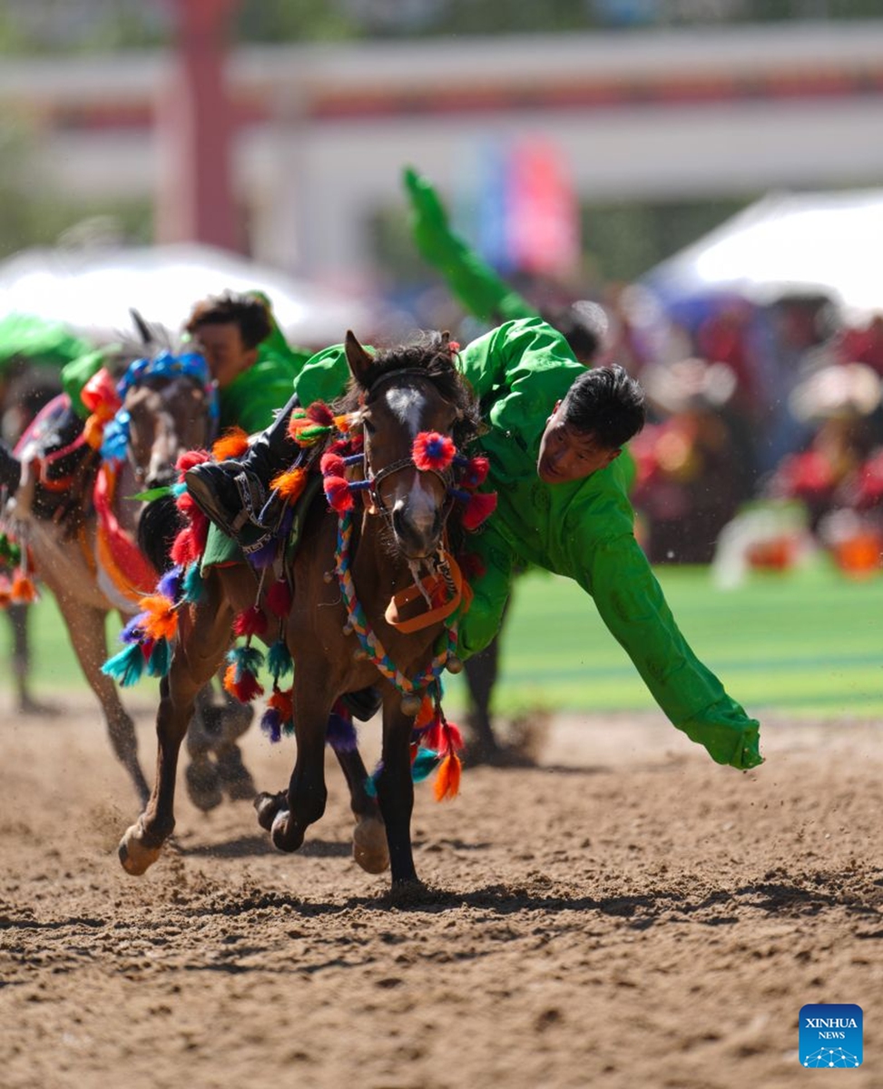 Riders show off equestrian stunts during the opening ceremony of the 44th Yushu horse racing festival in Yushu Tibetan Autonomous Prefecture, northwest China's Qinghai Province, July 25, 2026. The festival kicked off here on Saturday, and will last until August. (Xinhua/Du Xiaowei)