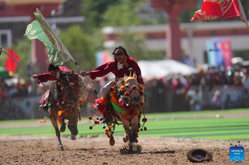 Riders show off equestrian stunts during the opening ceremony of the 44th Yushu horse racing festival in Yushu Tibetan Autonomous Prefecture, northwest China's Qinghai Province, July 25, 2026. The festival kicked off here on Saturday, and will last until August. (Xinhua/Du Xiaowei)