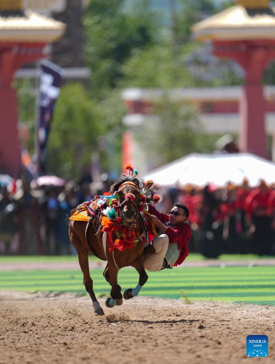 A rider shows off equestrian stunts during the opening ceremony of the 44th Yushu horse racing festival in Yushu Tibetan Autonomous Prefecture, northwest China's Qinghai Province, July 25, 2026. The festival kicked off here on Saturday, and will last until August. (Xinhua/Du Xiaowei)