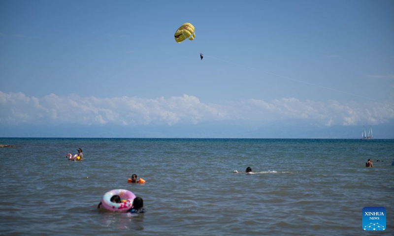 People enjoy themselves at Issyk-Kul Lake in Kyrgyzstan, on July 23, 2026. Issyk-Kul Lake, located in the northeastern part of Kyrgyzstan, covers an area of more than 6,000 square kilometers and ranks as the world's second-largest alpine lake. (Xinhua/Li Renzi)