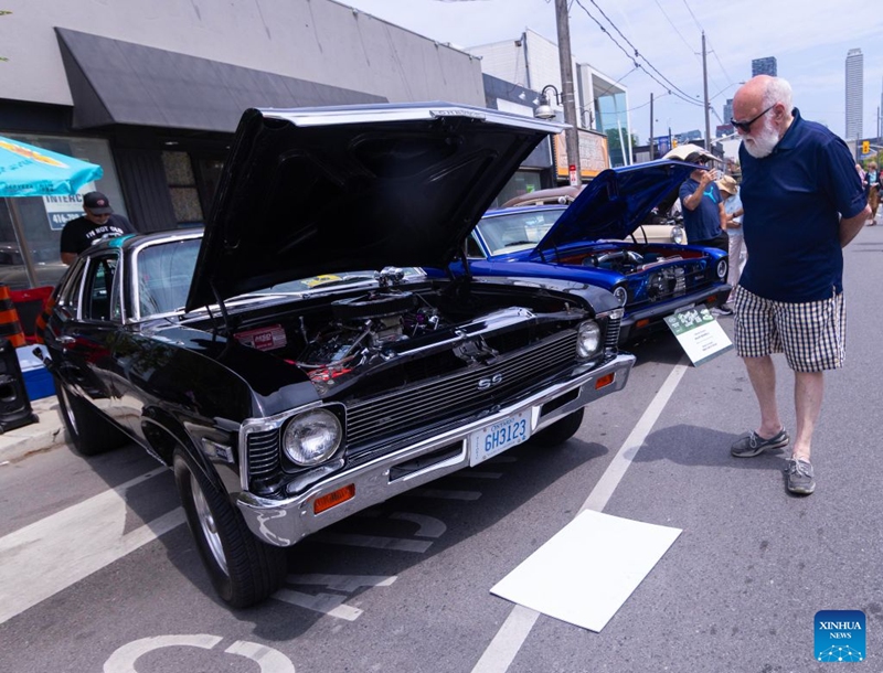 People view vintage cars on display at the Dream Wheels on Eglinton 2026 in Toronto, Canada, July 25, 2026. The event was held here on Saturday featuring a curated showcase of classic cars. (Photo by Zou Zheng/Xinhua)