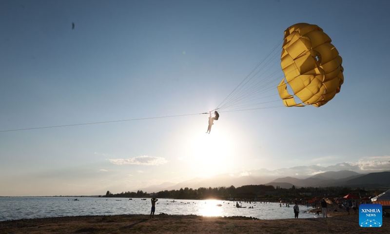 People enjoy themselves at Issyk-Kul Lake in Kyrgyzstan, on July 24, 2026. Issyk-Kul Lake, located in the northeastern part of Kyrgyzstan, covers an area of more than 6,000 square kilometers and ranks as the world's second-largest alpine lake. (Photo by Roman/Xinhua)