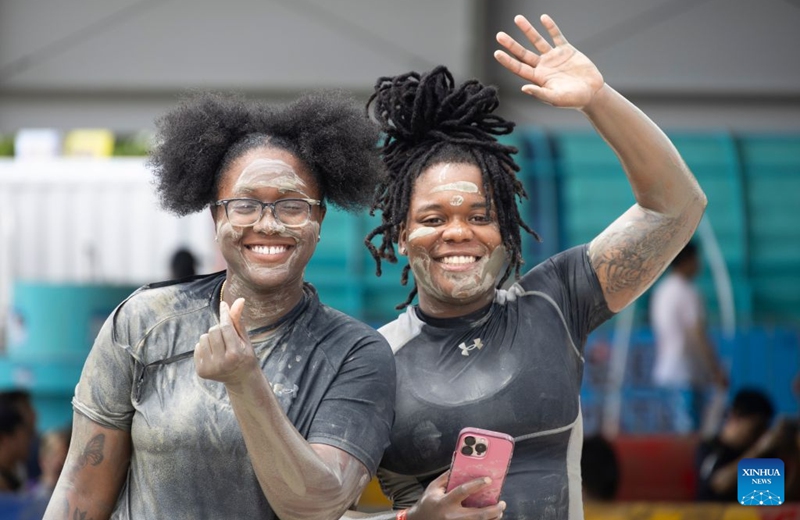 Tourists pose for photos during the 2026 Boryeong Mud Festival at the Daecheon beach in Boryeong, South Korea, July 25, 2026. (Photo by Jun Hyosang/Xinhua)
