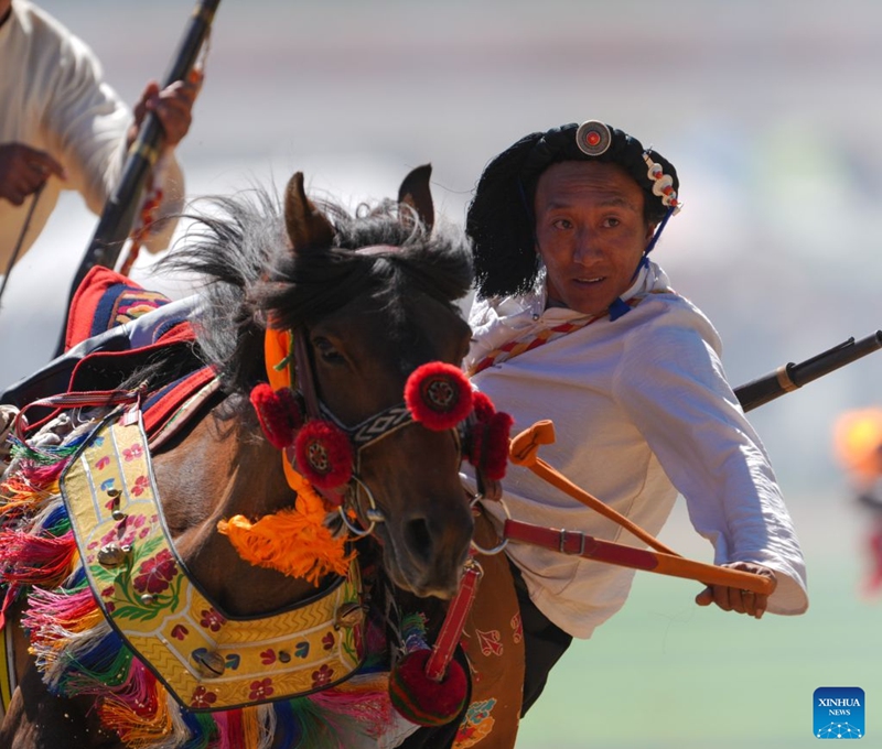 A rider shows off equestrian stunts during the opening ceremony of the 44th Yushu horse racing festival in Yushu Tibetan Autonomous Prefecture, northwest China's Qinghai Province, July 25, 2026. The festival kicked off here on Saturday, and will last until August. (Xinhua/Du Xiaowei)