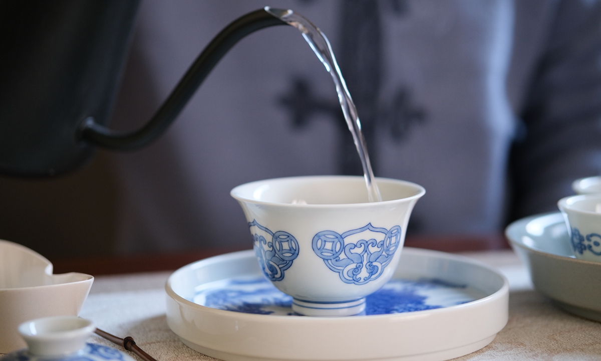 A person makes tea with a blue-and-white porcelain tea set made in Jingdezhen. Photo: VCG