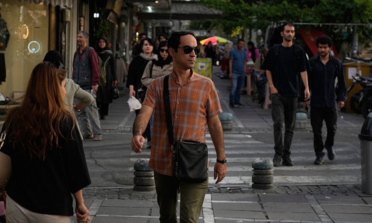 People walk along a sidewalk in downtown Tehran, Iran, on July 22, 2026. 