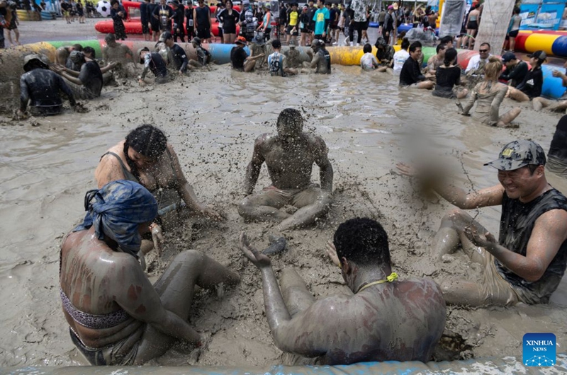 Tourists enjoy a mud experience during the 2026 Boryeong Mud Festival at the Daecheon beach in Boryeong, South Korea, July 25, 2026. (Photo by Jun Hyosang/Xinhua)