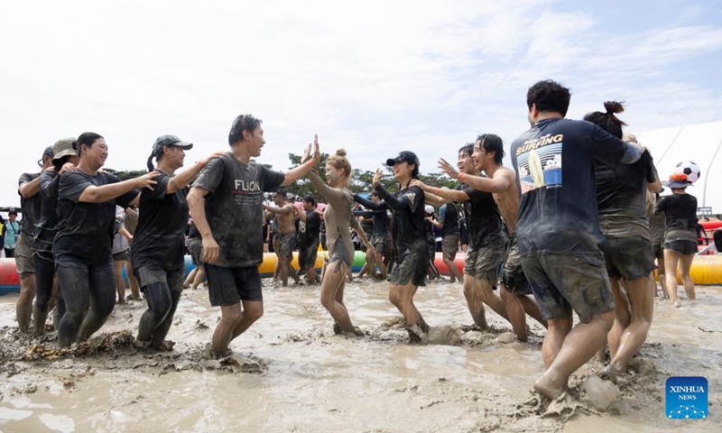 Tourists enjoy a mud experience during the 2026 Boryeong Mud Festival at the Daecheon beach in Boryeong, South Korea, July 25, 2026. (Photo by Jun Hyosang/Xinhua)