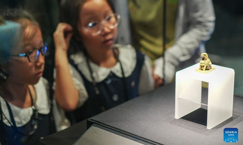 Children look at an exhibit at Jiangkou sunken silver museum in Meishan City, southwest China's Sichuan Province, July 25, 2026. Museums have become popular in hot summer in many regions across China, drawing large crowds seeking both knowledge and coolness. (Photo by Weng Guangjian/Xinhua)