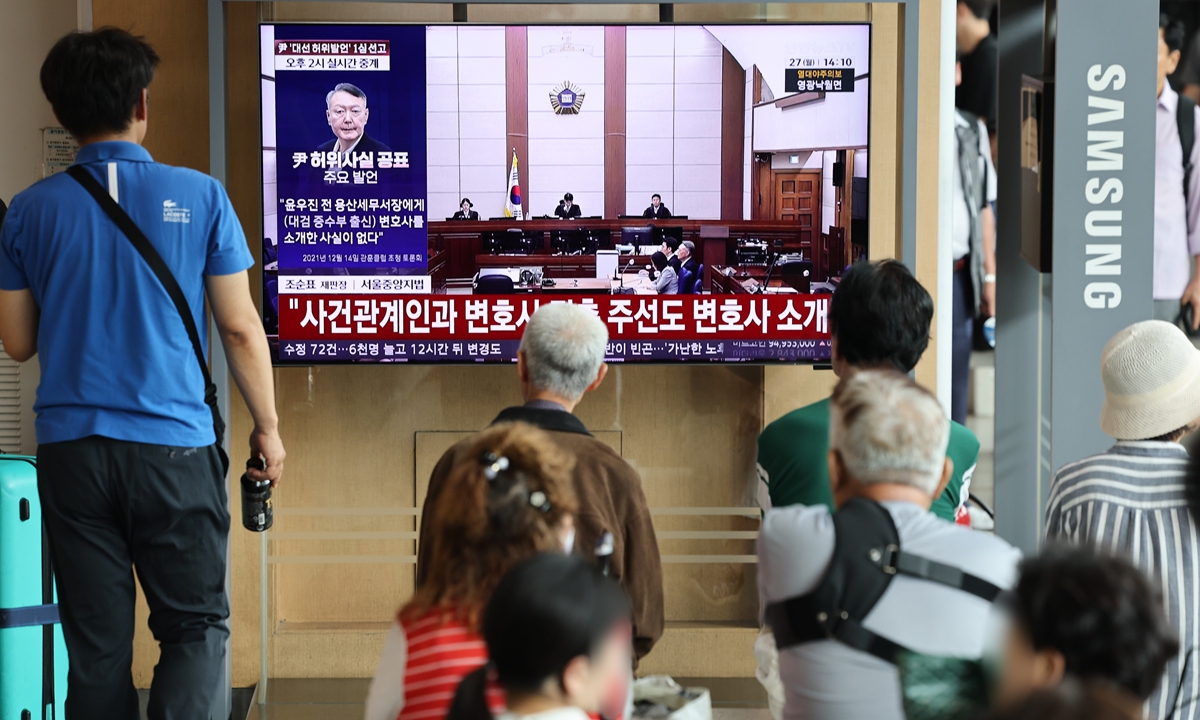 People watch a television report at Seoul Station in Seoul, South Korea, on July 27, 2026, as a court sentences former South Korean president Yoon Suk-yeol to 18 months in prison, suspended for three years, for making false statements during his 2022 presidential campaign. Photo: IC