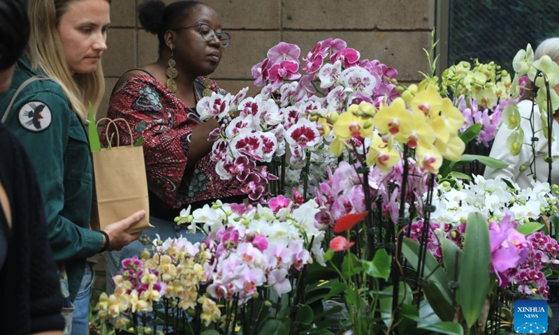 People look at flowers at an orchids trade fair at Golden Gate Park of San Francisco, the United States, July 25, 2026. (Photo by Liu Yilin/Xinhua)