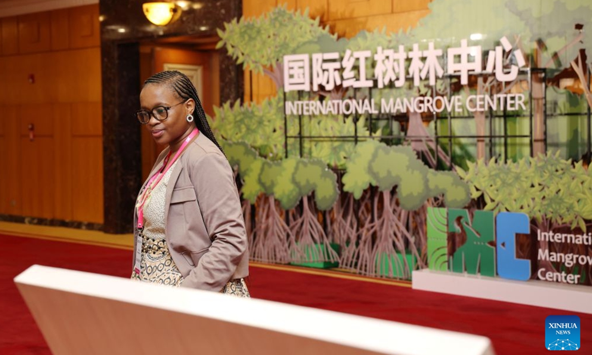A representative views a display board outside the conference hall of the first council meeting of the International Mangrove Center in Shenzhen, south China's Guangdong Province, July 26, 2026.