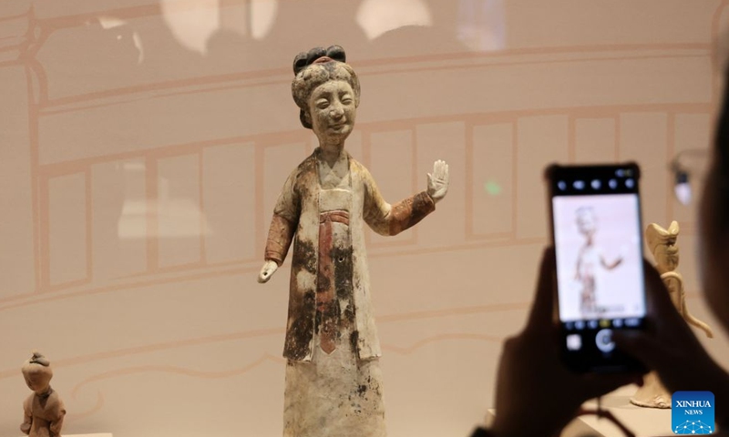A visitor takes a photo at the exhibition Smiles: Imprints of the Chinese Spirit in Cultural Relics at the Liaoning Provincial Museum in Shenyang, northeast China's Liaoning Province, July 26, 2026.