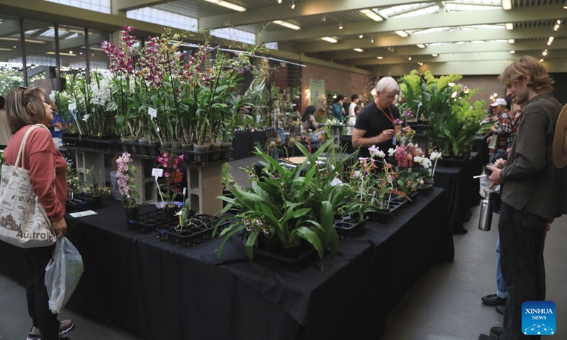 People look at flowers at an orchids trade fair at Golden Gate Park of San Francisco, the United States, July 25, 2026. (Photo by Liu Yilin/Xinhua)