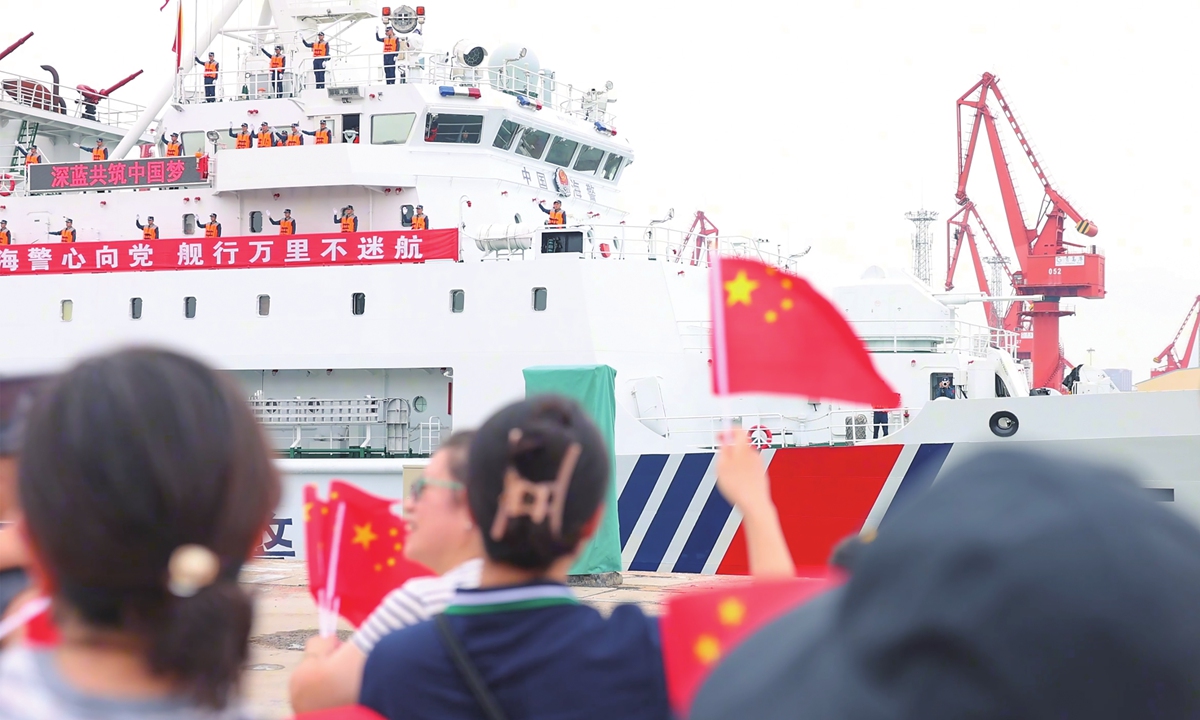People wave Chinese national flags to see off the China Coast Guard vessels Changshan and Wuhu as they depart Qingdao, East China's Shandong Province on July 27, 2026, for a 45-day high seas fisheries law-enforcement patrol in the North Pacific. Photo: Courtesy of China Coast Guard