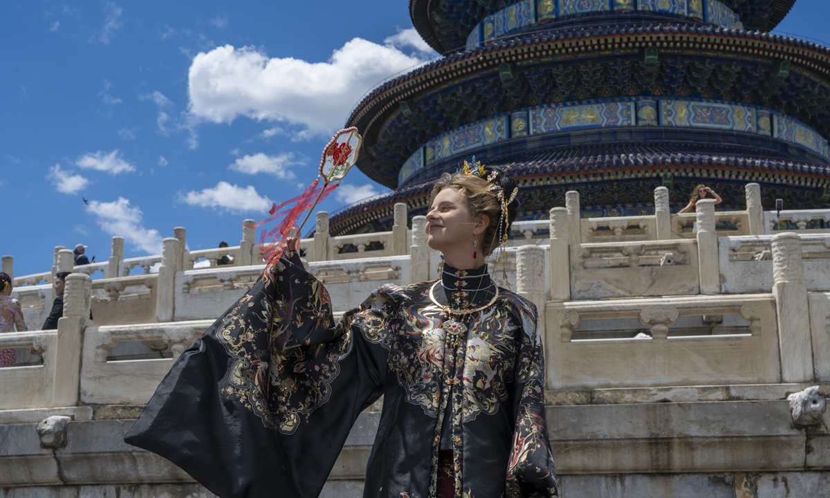 A foreign tourist wearing traditional Chinese clothing visits and takes photos in the Temple of Heaven in Beijing on June 9, 2026. Photo: VCG