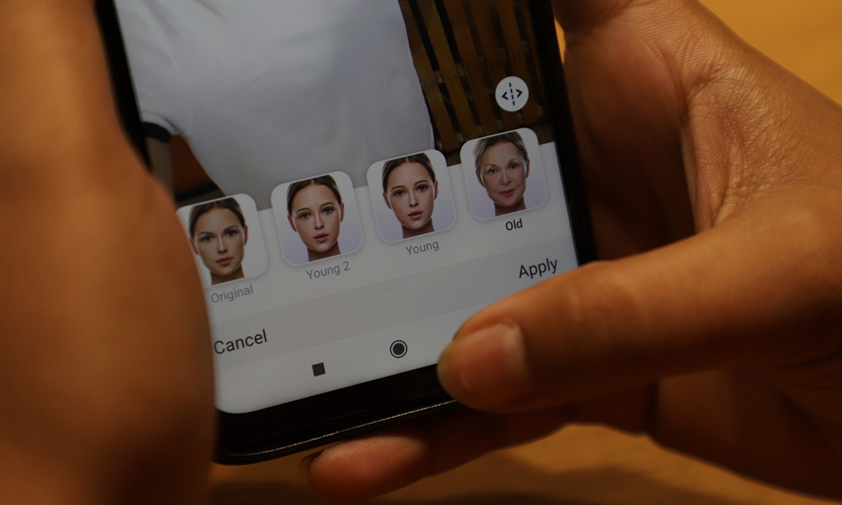 A user tries to edit a photo using an AI face-swapping application on a smartphone. Photo: VCG