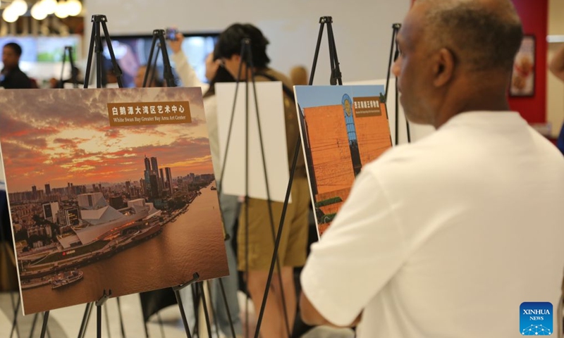 A visitor watches a photo exhibition during an event to promote tourism for Guangdong-Hong Kong-Macao Greater Bay Area, in East Rutherford, New Jersey, the United States, on July 26, 2026. South China's Guangdong province on Sunday showcased its vast cultural and tourism resources in the United States, inviting American visitors to experience the region's diverse attractions.(Xinhua/Liu Yanan)

