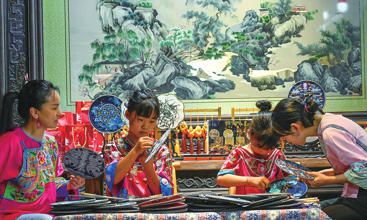 Children sew Yuzhou Miao embroidery under guidance at a workshop in Yuzhou ancient town, Youyang Tujia and Miao Autonomous County in Southwest China's Chongqing Municipality on July 28, 2026. Miao embroidery was included in the national intangible cultural heritage list in 2006. Photo: VCG
