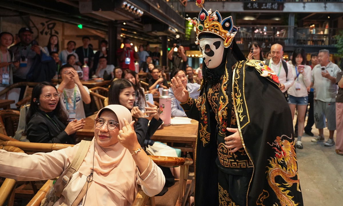 Foreign guests attending APEC events watch a Sichuan Opera face-changing performance in Chengdu, Southwest China's Sichuan Province, on July 28, 2026. A signature theatrical stunt unique to Sichuan Opera, face changing features performers switching intricately painted masks in the blink of an eye to convey shifts in character emotion and plot. Photo: VCG