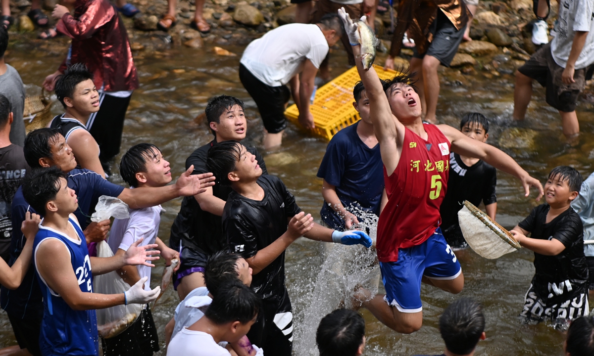 People scramble for live fish in a river during the Naoyu Festival in a village in Liuzhou, South China's Guangxi Zhuang Autonomous Region, on July 29, 2026. The festival is a traditional folk custom during which people battle to catch fish, which represent hopes for a good harvest. Photo: VCG