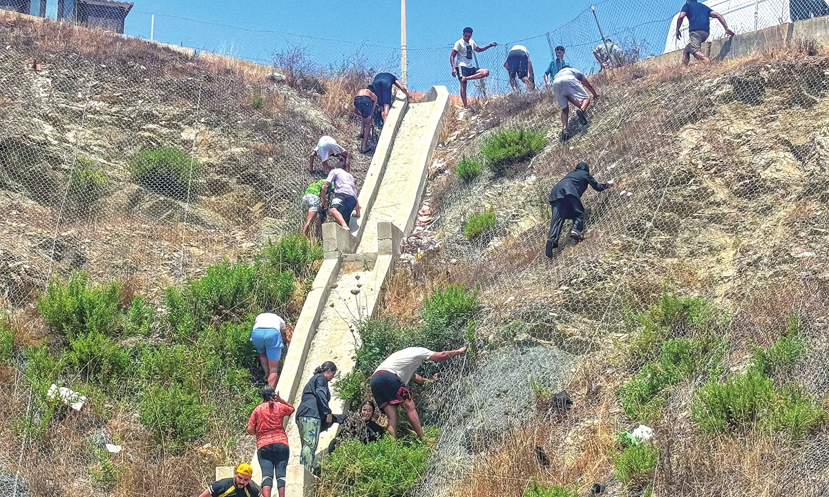 Migrants cross into Ceuta of Spain from Morocco on July 30, 2026, either by swimming or by climbing over the breakwater. Earlier on Thursday, Ceuta leader Juan Jesus Vivas had urged the national government to declare an emergency over the mass arrivals, media reported. Photo: VCG
