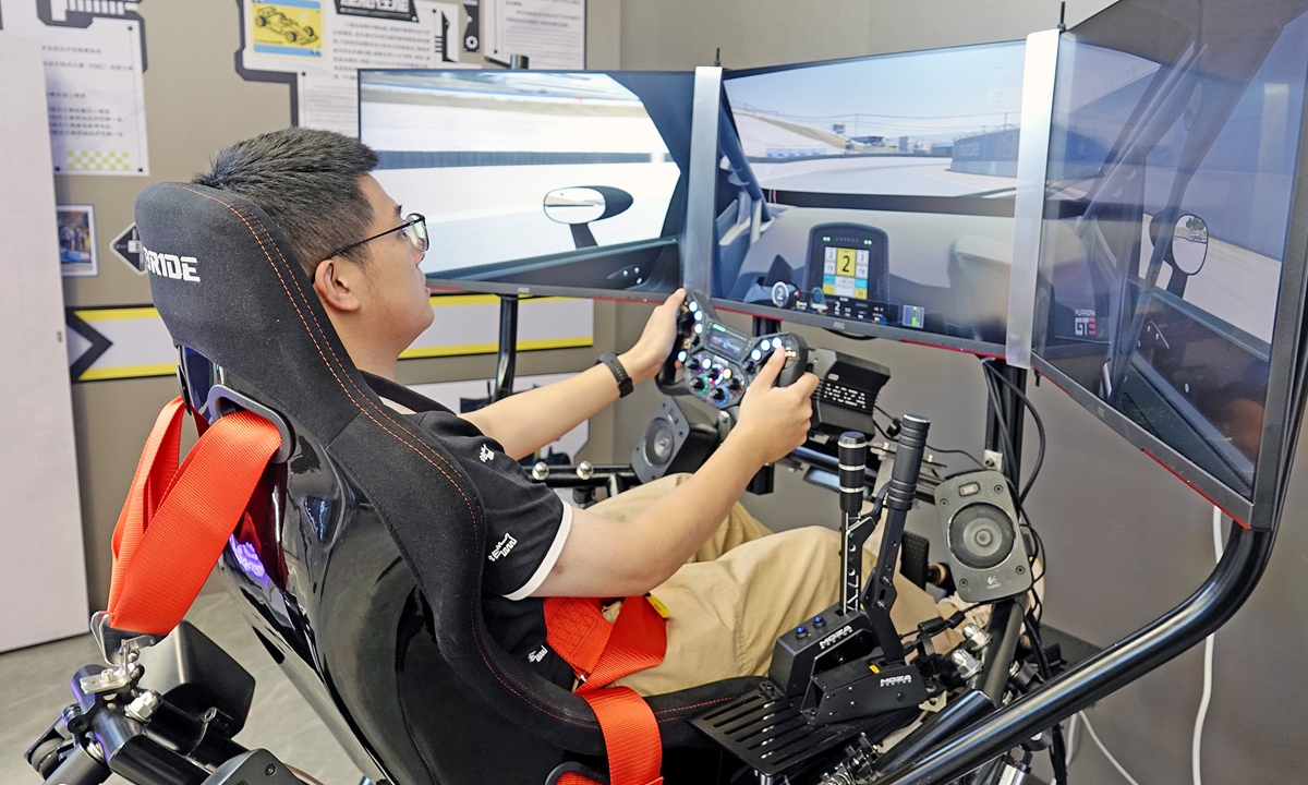 A visitor tries out a simulated driving system at the artificial intelligence (AI) city living room in Hangzhou, East China's Zhejiang Province on July 30, 2026. Its exhibition areas cover six cutting-edge sectors, including smart offices and intelligent transportation, showcasing Hangzhou's ambition to become the nation's leading city for AI innovation and development. Photo: VCG