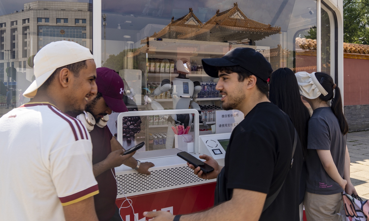 Foreign visitors experience a robotic kiosk at a park in Shenyang, Northeast China's Liaoning Province, on June 8, 2026. Photo: VCG