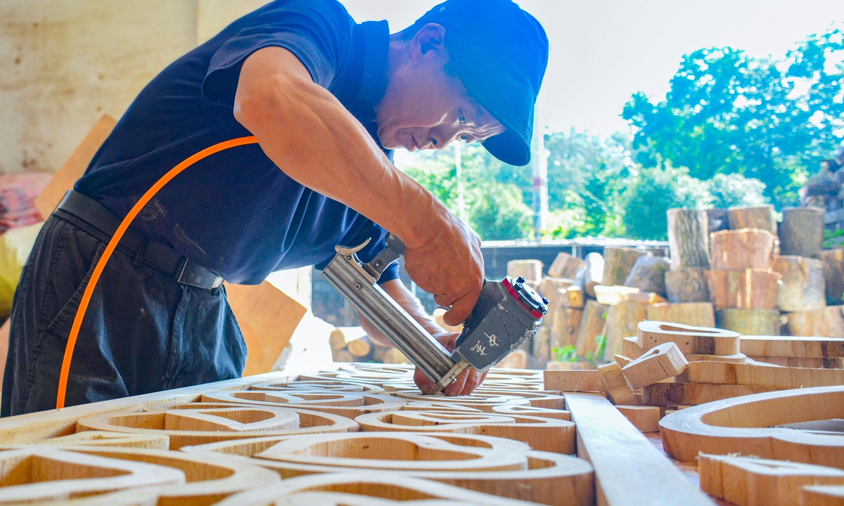 An employee works on a batch of French orders for decorative screens at a handicraft enterprise in Anqing, East China's Anhui Province, on July 31, 2026. In recent years, the company has utilized raw materials such as tea branches, mulberry twigs, and tree roots to create distinctive products, using creative design and meticulous processing. Its products are sold to over 60 countries and regions, including the US, the UK, and Italy. Photo: VCG