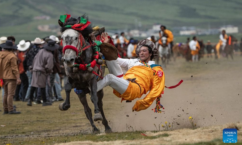 A herdsman shows off equestrian stunts during an equestrian performance event featuring traditional horse-riding skills in Litang County, southwest China's Sichuan Province, on July 31, 2026. (Photo by Xiang Wenjun/Xinhua)