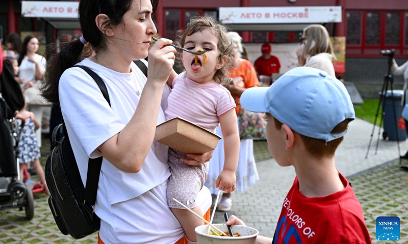 A woman feeds her child Chinese food during a Chinese cultural showcase at Huaming Park in Moscow, Russia, July 31, 2026.
A Chinese cultural exhibition and performance event featuring traditional Chinese dance, martial arts, cultural-and-creative products and cuisines kicked off here on Friday. The event runs until Oct. 4. (Xinhua/Feng Kaihua)