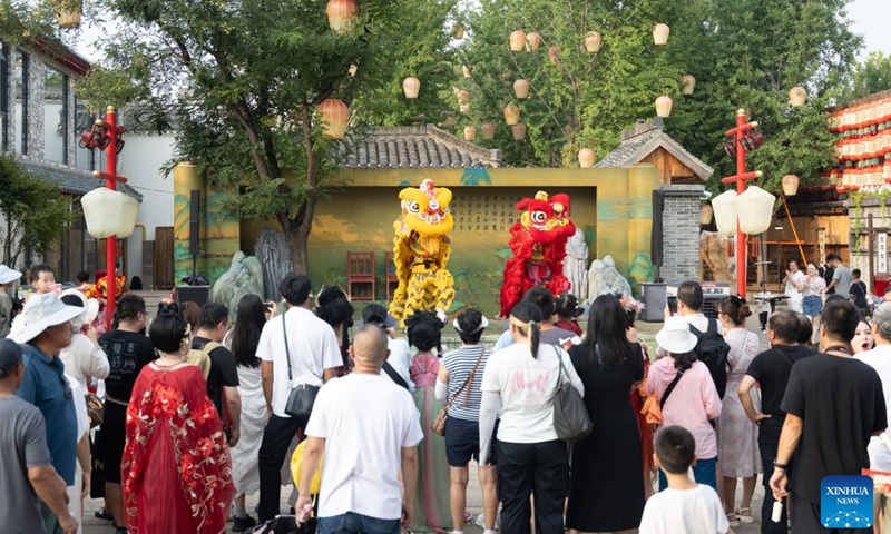 Tourists watch a lion dance performance at the Hetou Old Street scenic area in Fengnan District of Tangshan City, north China's Hebei Province, July 31, 2026.
Various performances including light shows and molten iron fireworks are staged here this summer, giving a boost to local tourism consumption. (Photo by Li Xiuqing/Xinhua)
