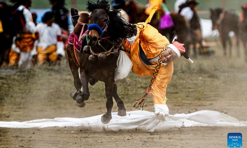 A herdsman shows off equestrian stunts during an equestrian performance event featuring traditional horse-riding skills in Litang County, southwest China's Sichuan Province, on July 31, 2026. (Photo by Xiang Wenjun/Xinhua)