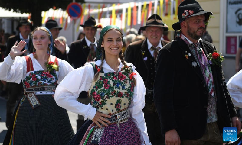 People participate in a traditional costume parade in Villach, Austria, Aug. 1, 2026. (Xinhua/He Canling)