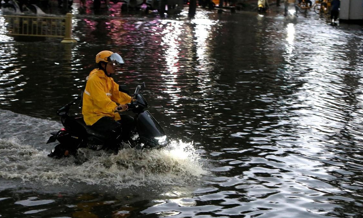 A delivery rider travels through a waterlogged street after heavy rainfall occurred in Xi'an, Northwest China's Shaanxi Province. Photo: VCG