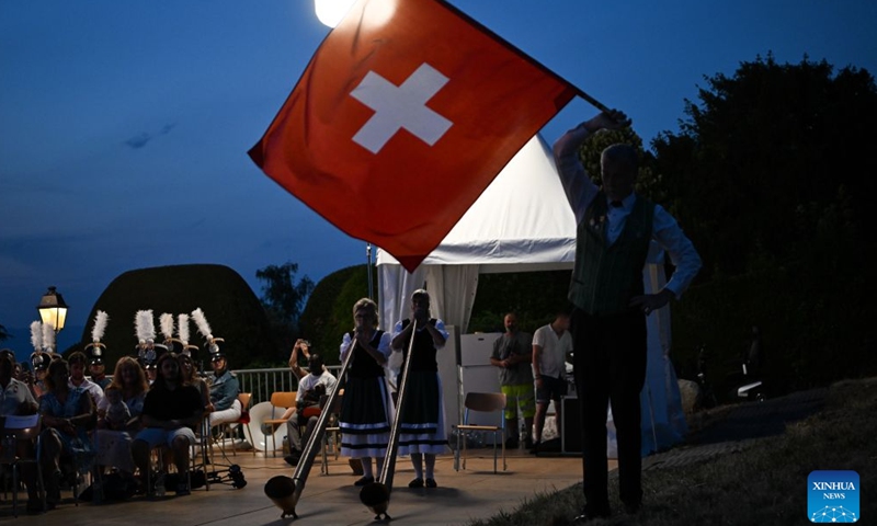 Artists in folk costumes play the traditional Swiss alpine horns during an event to celebrate the Swiss National Day in Geneva, Switzerland, Aug. 1, 2026. (Xinhua/Lian Yi)