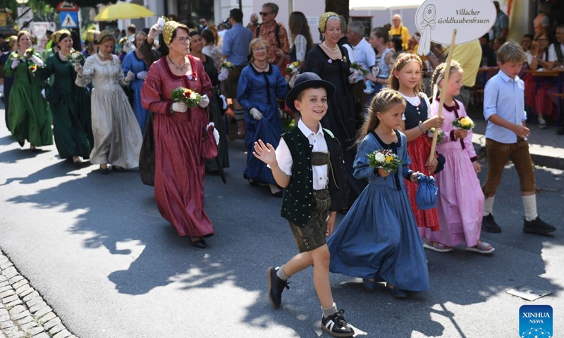 People participate in a traditional costume parade in Villach, Austria, Aug. 1, 2026. (Xinhua/He Canling)