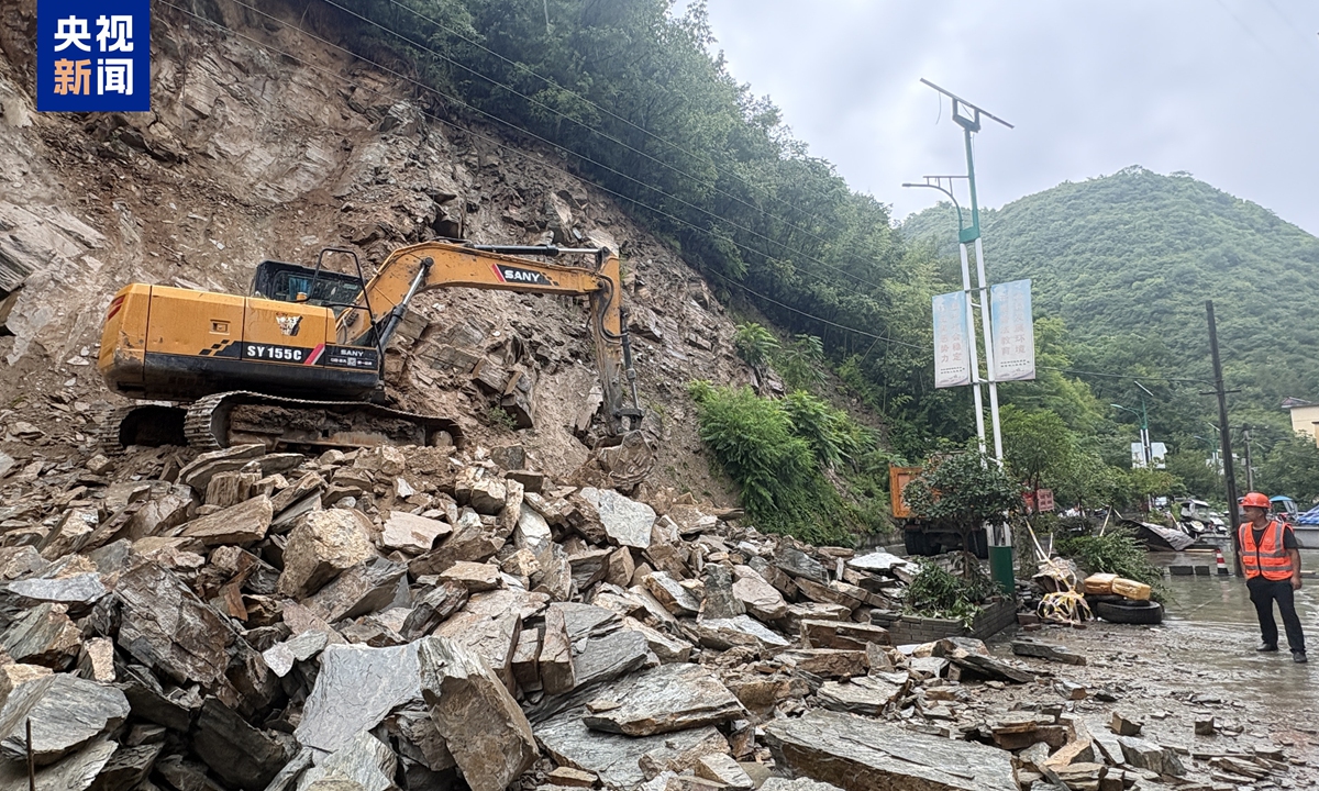 An excavator clears fallen rocks from a rain-soaked road in Northwest China's Shaanxi Province. Photo: CCTV News