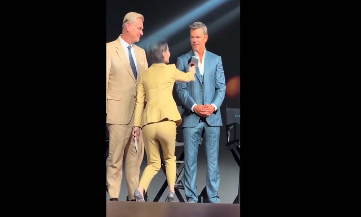 Chen Xuan, a bilingual host from Shanghai Media Group's International Channel Shanghai, crouches while handing a microphone to foreign cast members during the premiere of The Odyssey in Beijing on July 30, 2026. Photo: Screenshot from an online video