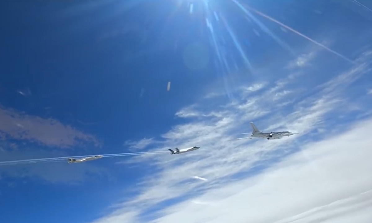 An H-6N bomber (front) flies under the escort of two J-20 stealth fighters, with a large missile mounted under its fuselage. Photo: Screenshot from CCTV News