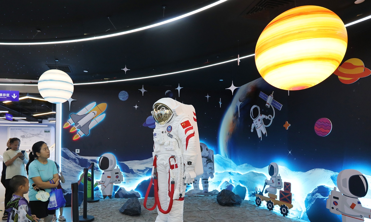Local residents view an astronaut spacesuit at an aeronautics and astronautics science and technology museum in Zhengzhou, Central China's Henan Province, on August 5, 2026. Covering 5,000 square meters, the newly opened museum features more than 20 flight simulators and five themed aviation zones combining science education with practical operations. Photo: VCG