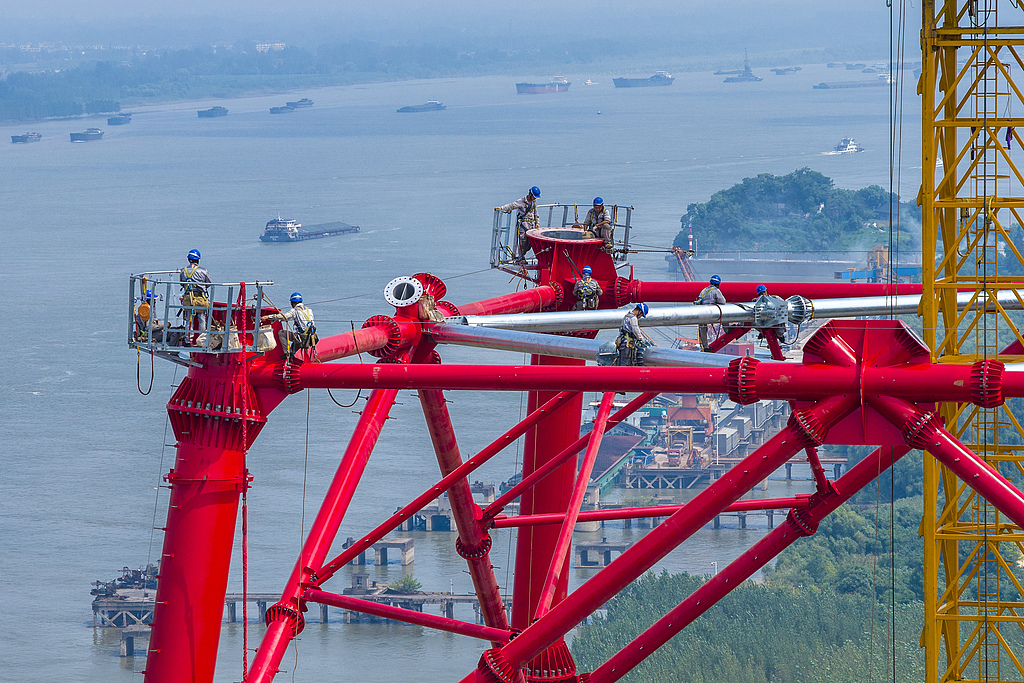 Workers assemble a transmission tower at the Gansu-Zhejiang ultra-high-voltage power transmission project in Wuhu, East China's Anhui Province, on August 6, 2026. Spanning 2,370 kilometers, the project is a key part of China's west-to-east power transmission program. It will deliver more than 36 billion kilowatt-hours of electricity per year to East China's Zhejiang Province, supporting optimization of the energy structure and green, high-quality development across the Yangtze River Delta. Photo: VCG