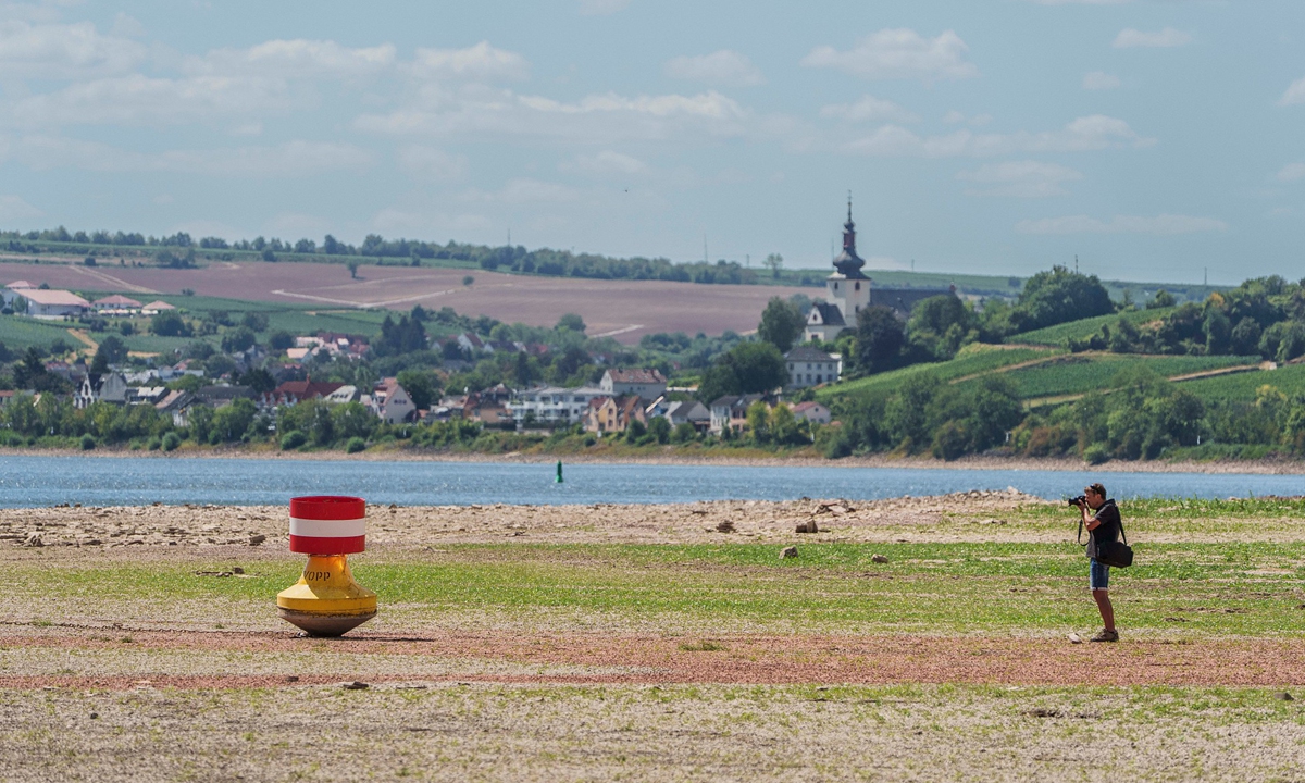 A man photographs a navigation marker during low water on August 6, 2026 in Nierstein, Germany. The Rhine has receded significantly near Nierstein due to the low water levels. Photo: VCG