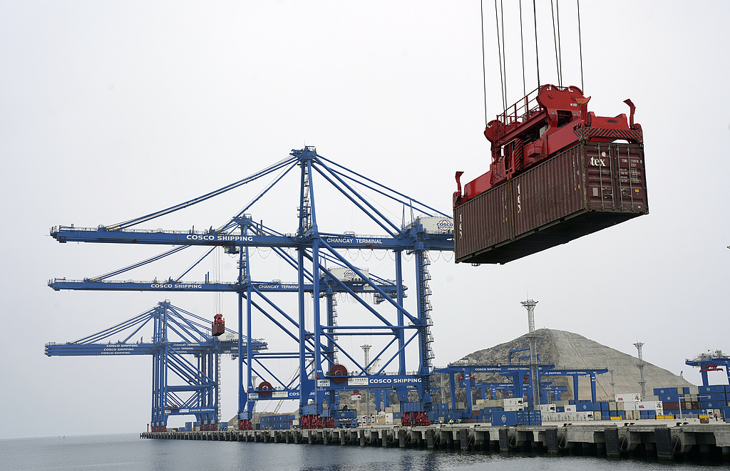 A container is lifted by a crane backdropped by the construction of the Chinese-funded port, in Chancay, Peru, on October 29, 2024. Photo: VCG