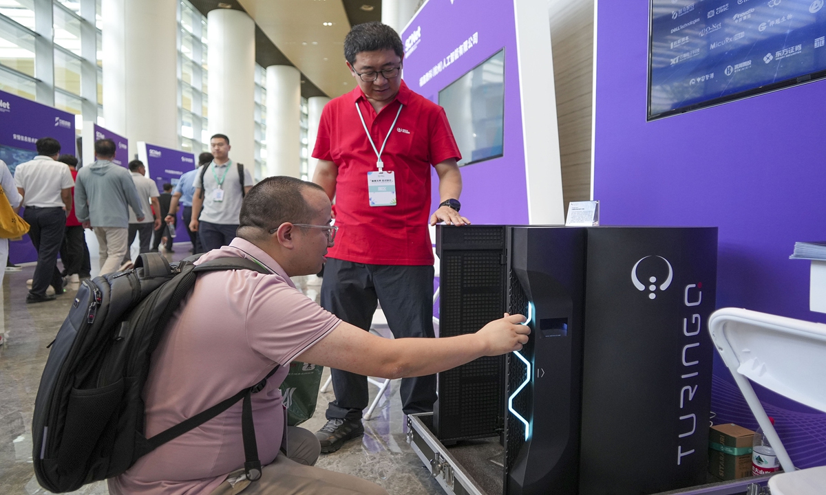 A spectator explores TuringQ Gen2 large-scale hybrid integrated photonic quantum computer at HIECO 2026 Intelligent Computing Application Conference, during which multiple AI hardware and software companies showcased products and solutions in intelligent computing, AI infrastructure and applications in Zhengzhou, Central China's Henan Province, on July 9, 2026. Photo: China News Service