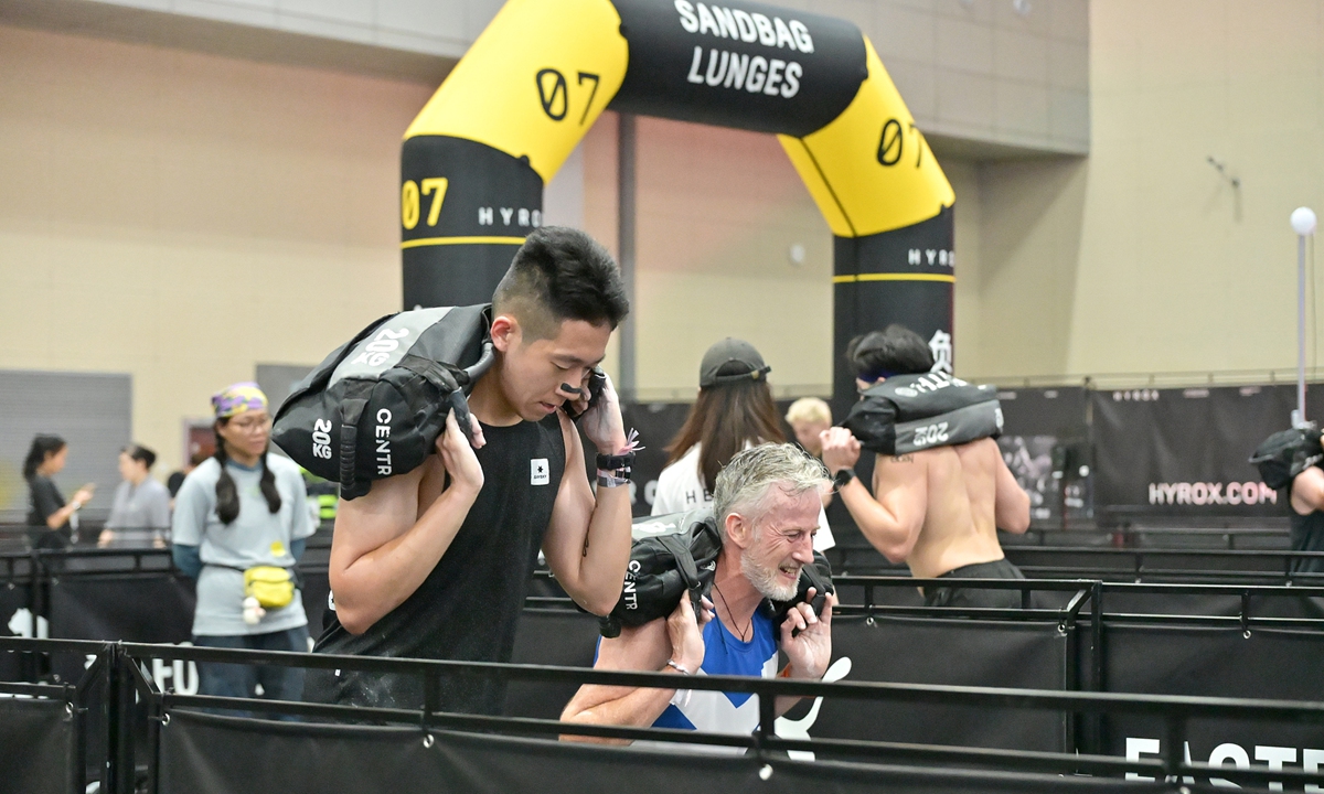 Hyrox participants do sandbag lunges during an event in Hangzhou, East China's Zhejiang Province on July 4, 2026. Photo: VCG
