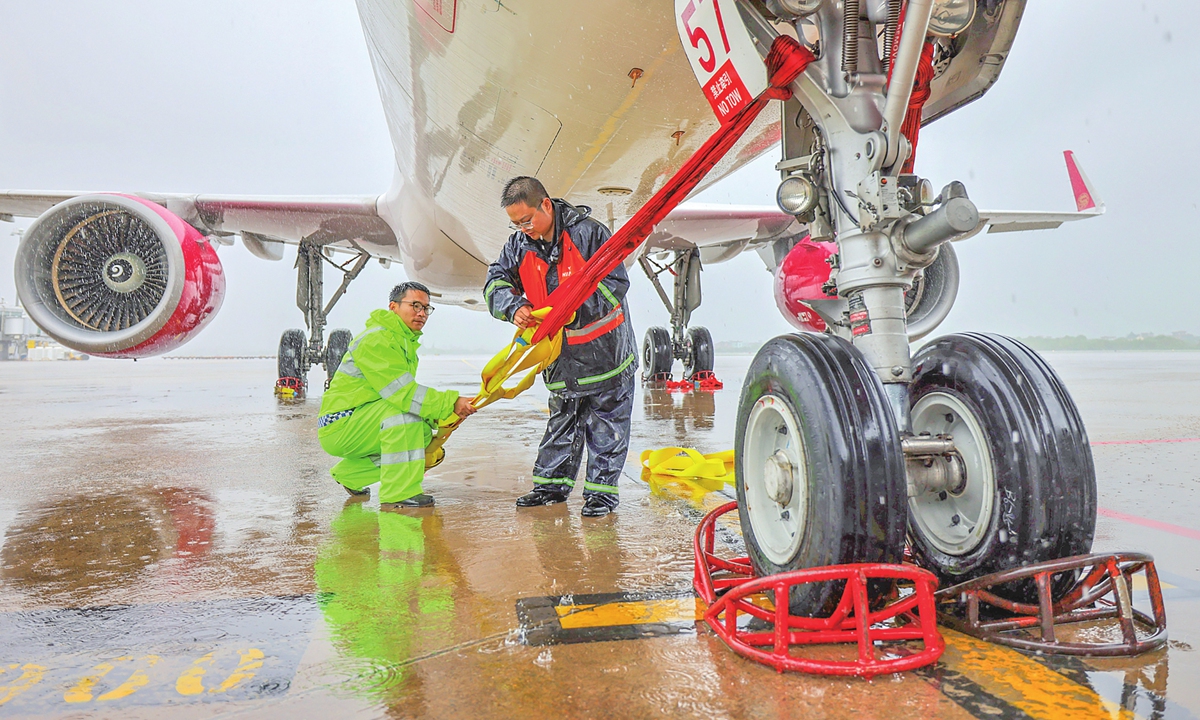 Staff members secure aircraft at Hangzhou Xiaoshan International Airport to prepare for Typhoon Dolphin on August 9, 2026. Photo: VCG