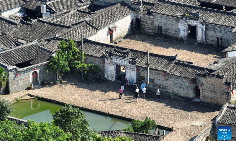 A drone photo taken on Aug. 5, 2026 shows tourists visiting a historical compound at Peitian Village, Xuanhe Town, Liancheng County, Longyan City, southeast China's Fujian Province.