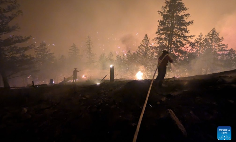 This photo provided by the BC Wildfire Service on Aug. 8, 2026 shows firefighters putting out a wildfire near Okanagan Valley in the Southern Interior of British Columbia, Canada. The western Canadian province of British Columbia (B.C.) declared a provincial state of emergency on Saturday as fast-spreading wildfires threatened several communities. (BC Wildfire Service/Handout via Xinhua)
