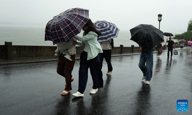 Visitors walk in the rain on the Duanqiao Bridge (Broken Bridge) at the West Lake scenic area in Hangzhou, east China's Zhejiang Province, Aug. 9, 2026. China's national observatory on Sunday activated a red alert -- the highest level in the country's typhoon warning system -- as Typhoon Dolphin approaches. (Photo: Xinhua)